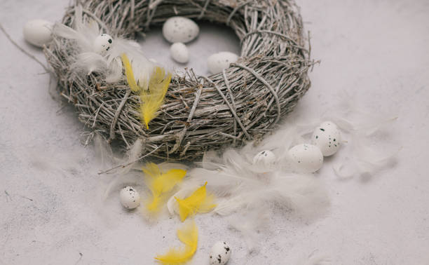 istock Real still life. White and yellow feathers with quail eggs on Easter wreath. 1305297631