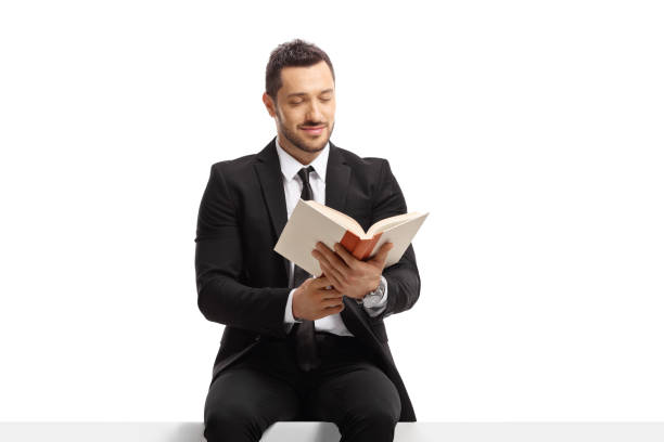 istock Businessman sitting on a blank banner and reading a book 1305302166