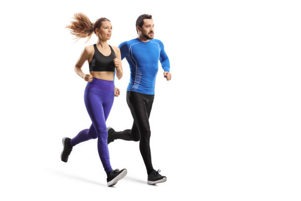 projectile complet de longueur d’un jeune homme et femme dans des sportswear fonctionnant ensemble - exercising running women jogging photos et images de collection