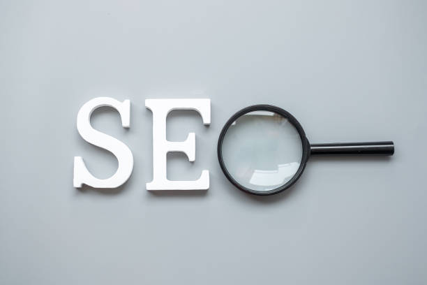 istock SEO (Search Engine Optimization) text and magnifying glass on gray background. Idea, Vision, Strategy, Analysis, Keyword and Content concept 1305304487