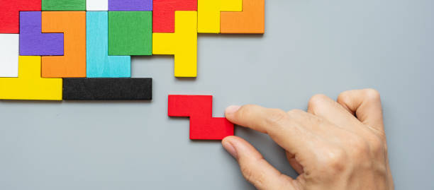 istock hand connecting geometric shape block with colorful wood puzzle pieces. logical thinking, business logic, Conundrum, decision, solutions, rational, mission, success, goals and strategy concepts 1305305712