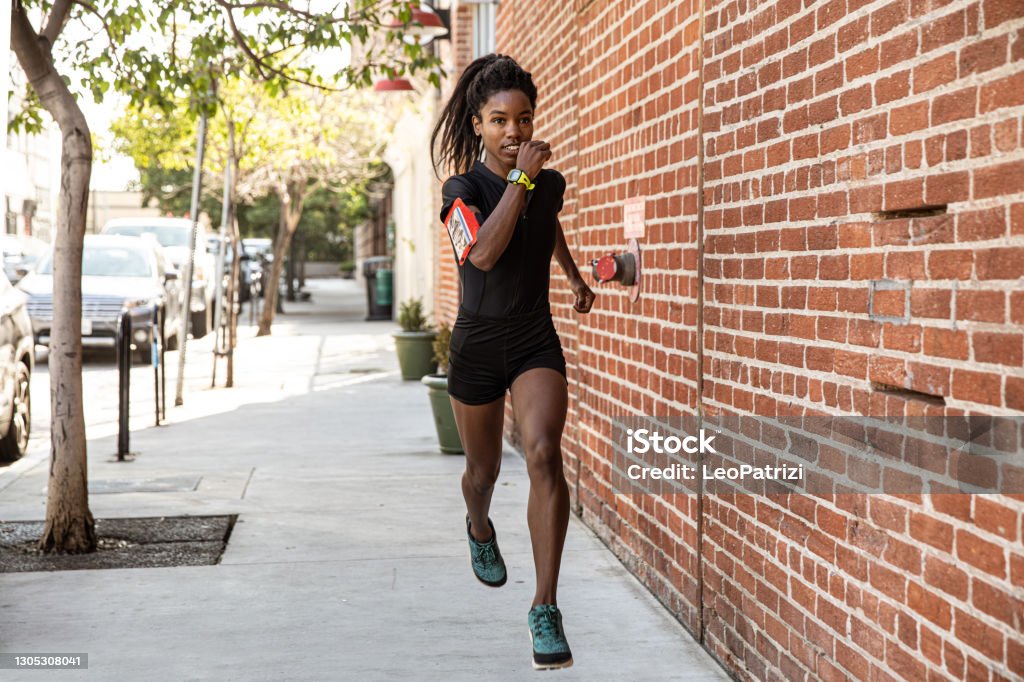 Athletic woman running outdoors Afro american woman running outdoors Running Stock Photo