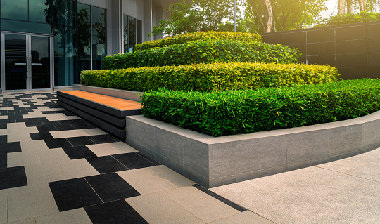 Beautiful outdoor gardening decoration with a bench of a modern office building, outdoor gardening image for corporate buildings concept.