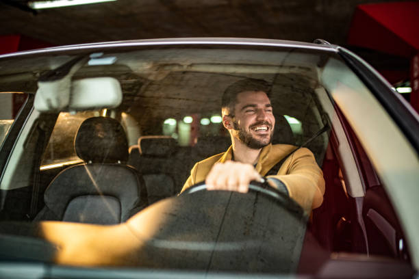istock Man driving a car in public garage. 1305310978