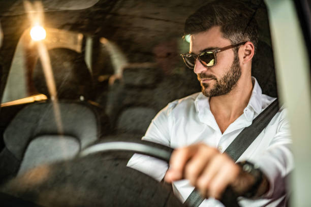 istock Man driving a car in public garage. 1305312165