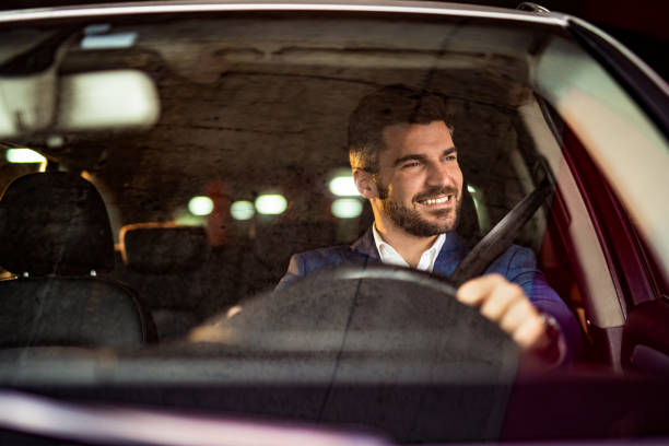 istock Man driving a car in public garage. 1305312346
