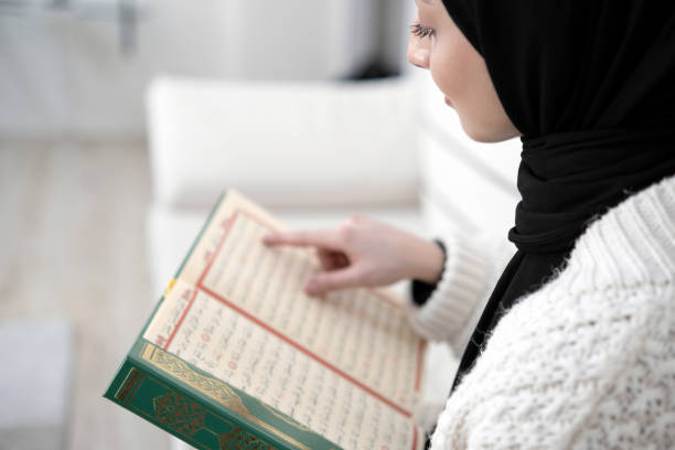 Muslim young woman reading Koran