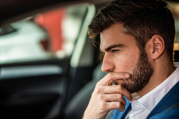 istock Thoughtful businessman driving a car. 1305312660