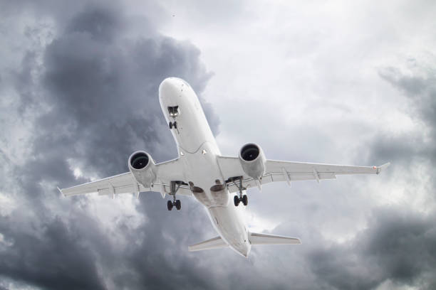 istock white plane take off in stormy grey and white clouds on blue sky background 1305312734