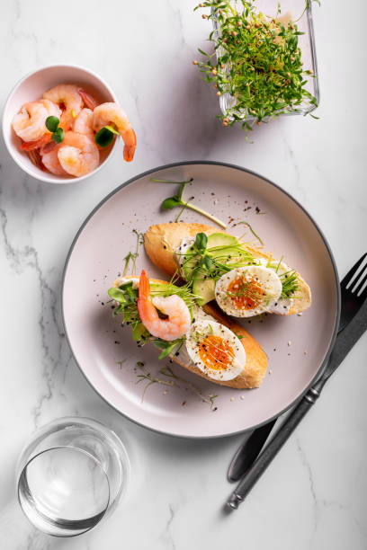 istock Breakfast with bruschetta with shrimps, eggs and microgreens in a plate 1305312898