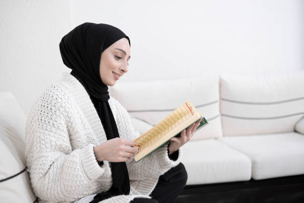 Muslim young woman reading Koran stock photo