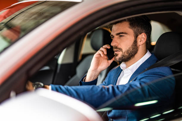 istock Handsome businessman driving a car in public garage. 1305313650
