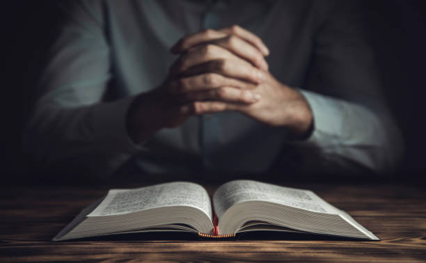 istock prayer hands on a Holy Bible 1305313747