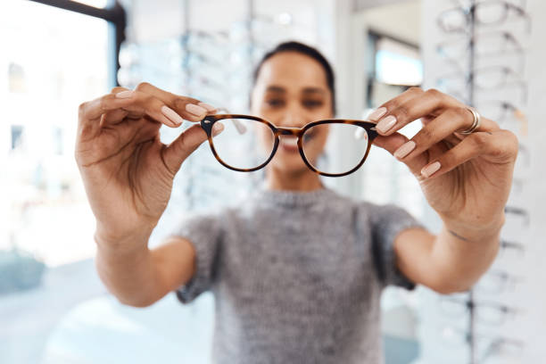 You've got to see it to believe it Shot of a young woman buying a new pair of glasses at an optometrist store myopia photos stock pictures, royalty-free photos & images