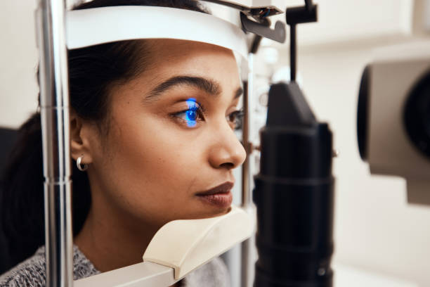 Keep as still as possible Shot of a young woman getting her eye’s examined with a slit lamp optometry photos stock pictures, royalty-free photos & images