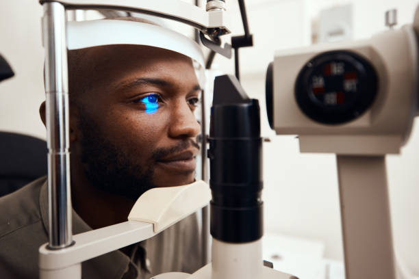 Life is a lot brighter with better vision Shot of a young man getting his eye’s examined with a slit lamp lens optical instrument stock pictures, royalty-free photos & images