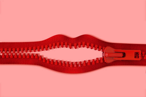 Mouth made of red zipper on pink background - Concept of violence against women and communication issues stock photo