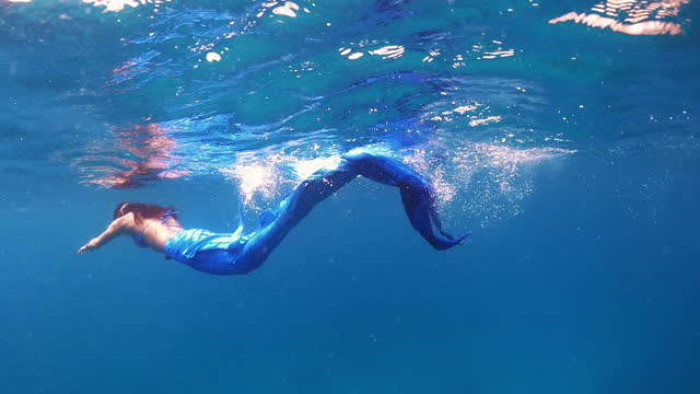 Asian women wearing Mermaid dress and diving in crystal clear water in the sea ocean