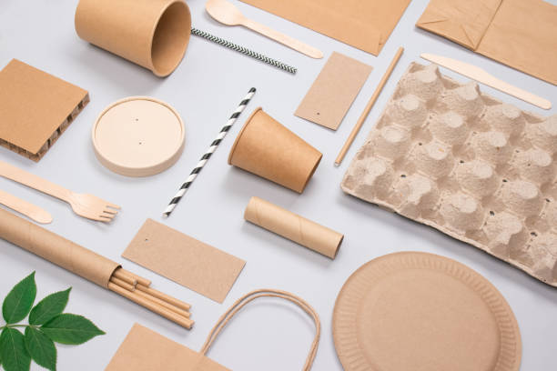 istock Flat lay composition, set of eco-friendly tableware and kraft paper food packaging on light gray background. Street food paper packaging - cups, plates, straws, containers and paper bags. Mockup 1305316695