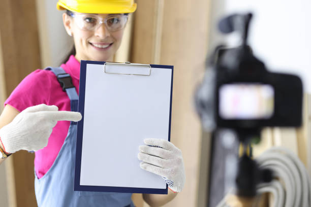 istock Woman builder holding documents in hands and shooting video on camera 1305316718