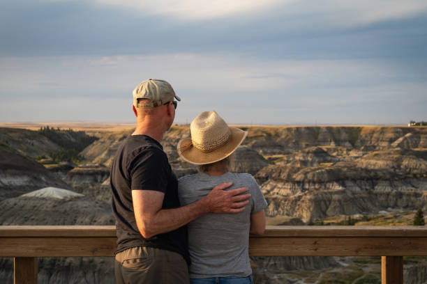 Senior Couple Looking at View at Horseshoe Canyon Near Drumheller in Alberta, Canada Active senior couple looking at view at Horseshoe Canyon near Drumheller in Alberta, Canada. drumheller stock pictures, royalty-free photos & images