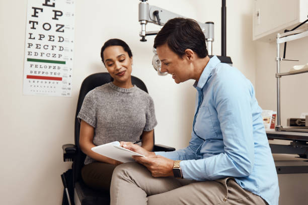 Do you have any health issues in your family? Shot of a young woman having an eye exam by an optometrist eye care professional stock pictures, royalty-free photos & images