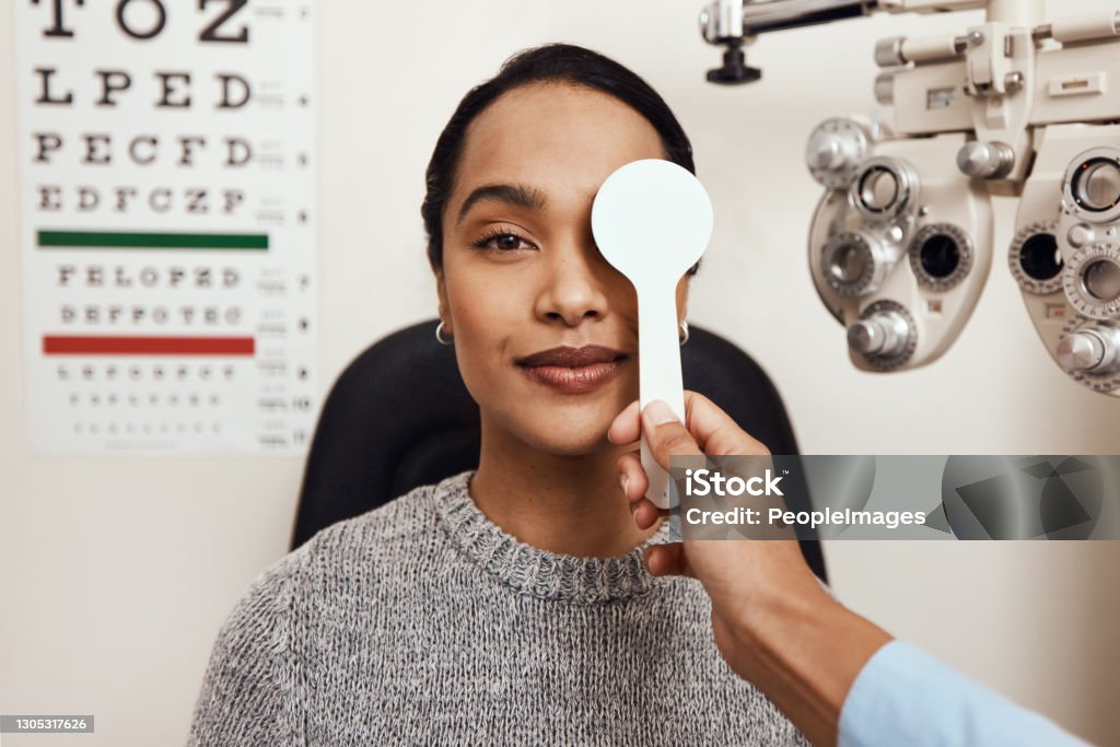 One little eye test goes a long way Shot of an optometrist covering her patient’s eyes with an occluder during an eye exam Eyesight Stock Photo