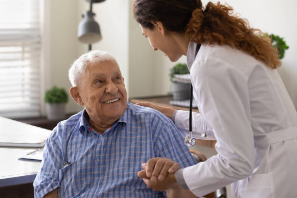 Close up caring nurse holding smiling mature patient hand Close up caring nurse holding smiling mature patient hand at meeting in hospital, doctor caregiver wearing uniform comforting and supporting senior man, good news about treatment, empathy and care alzheimer patient stock pictures, royalty-free photos & images