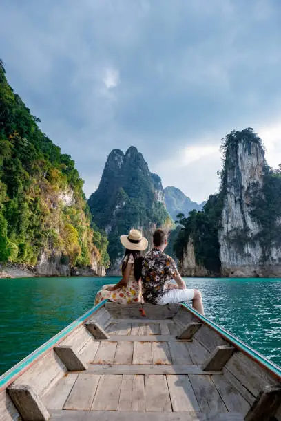 couple on longtail boat visiting Khao Sok national park in Phangnga Thailand, Khao Sok National Park with longtail boat for travelers, Cheow Lan lake, Ratchaphapha dam. man and woman mid age vacation