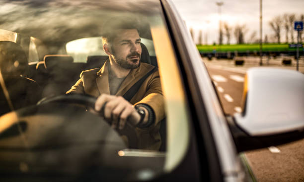 istock Young businessman driving a car. 1305324799