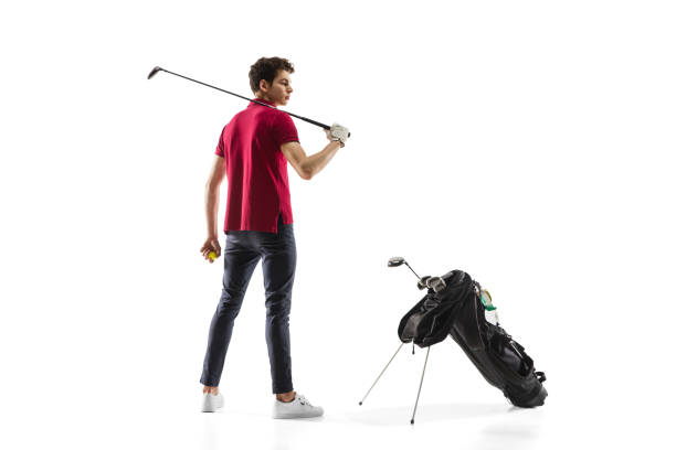jogador de golfe em um treinamento de camisa vermelha, praticando isolado no fundo do estúdio branco - golf green practicing sports training - fotografias e filmes do acervo