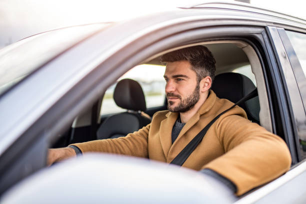istock Mid adult man driving a car. 1305324883