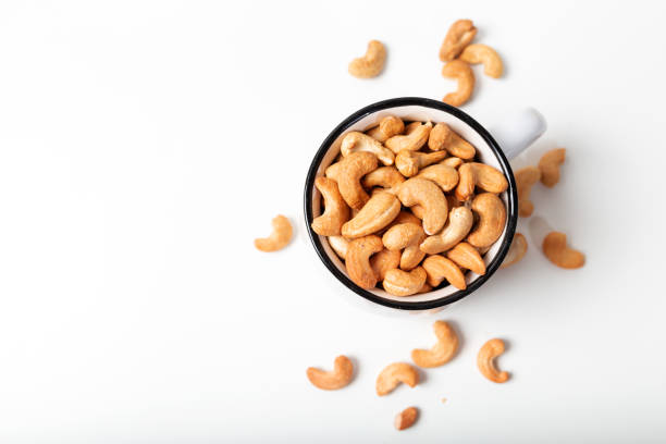 istock Cashew fruit in the white cup on  white background. Top view. 1305325306