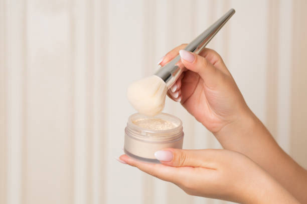 femme avec une brosse utilisant la poudre lâche - poudre pour le visage photos et images de collection