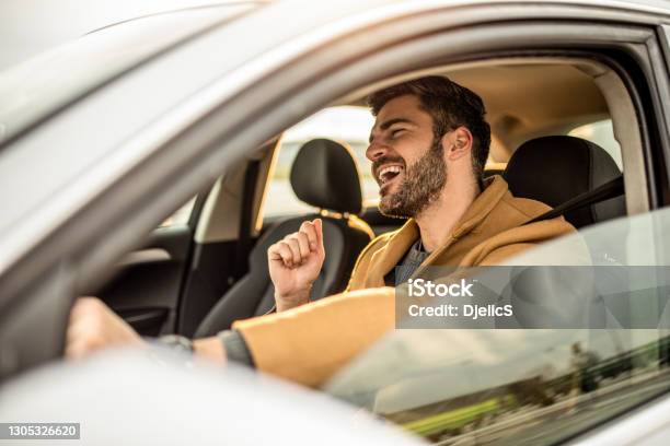Happy Mid Adult Man Driving A Car And Singing Stock Photo - Download Image Now - Car, Driving, Men