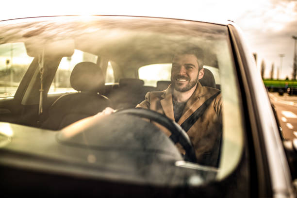 istock Happy man driving a car on sunset. 1305326738