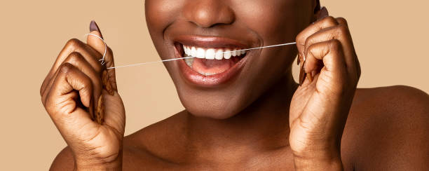 Young black woman using dental floss, closeup Perfect Smile, Toothcare, Clean Fresh Mouth And Oral Treatment Concept. Closeup cropped view of unrecognizable smiling black woman using dental floss, doing morning routine, panorama, banner brushing teeth stock pictures, royalty-free photos & images