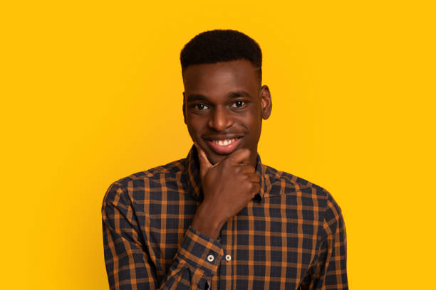 istock Handsome African American Guy Touching Chin And Looking At Camera With Interest 1305327388