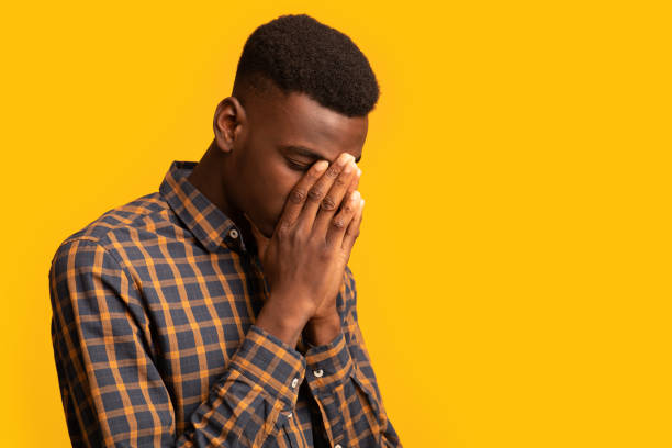 istock Upset black guy covering face with two hands in despair 1305327550