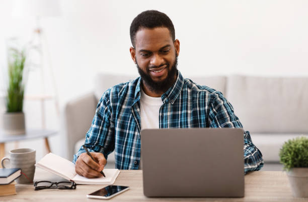 istock Black Business Guy Working At Laptop Taking Notes In Office 1305327782