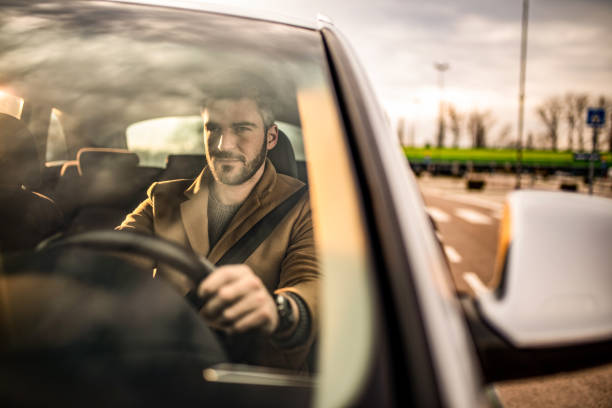 istock Businessman driving a car on sunset. 1305327862