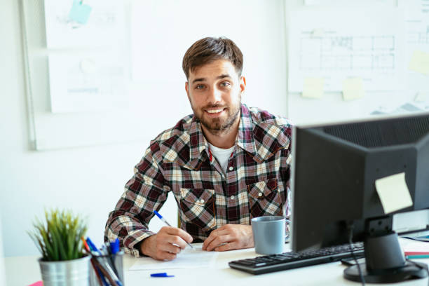 istock Entrepreneur filling out tax return form and looking at camera 1305327873