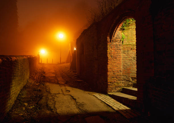 Atmospheric pathway among old village walls by night