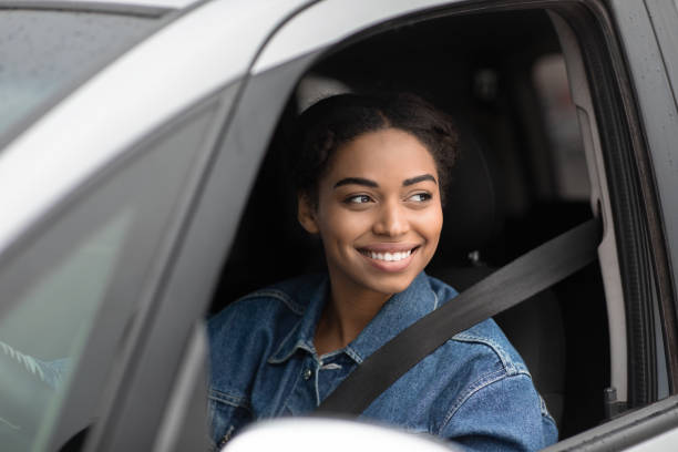 Meeting with friend on road in city, friendly taxi driver or flirt at traffic in town Meeting with friend on road in city, friendly taxi driver or flirt at traffic in town. Smiling millennial african american lady with seat belt looking outside window to another car, copy space taxi photos stock pictures, royalty-free photos & images