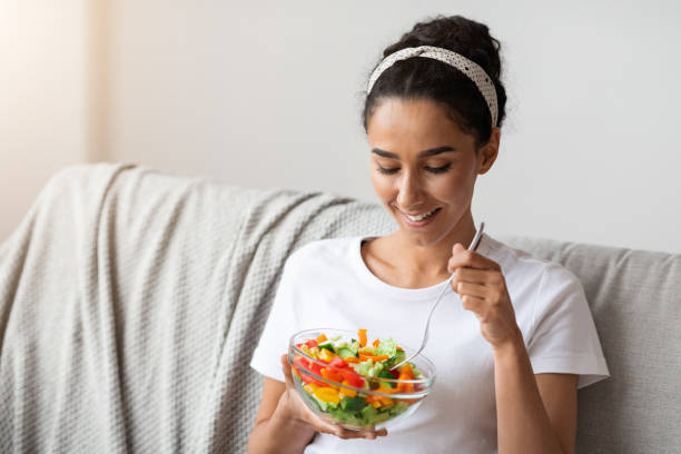 istock Smiling millennial woman eating vegetables, copy space 1305330703