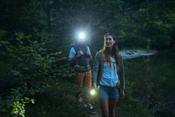 istock Hikers walking with flashlights in the woods 1305330710