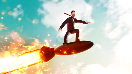 Concept image of man - perhaps an entrepreneur - who rides a rocket through the air. Maybe he is trying to reach his goals fast.