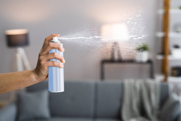 woman using air spray - air freshener imagens e fotografias de stock