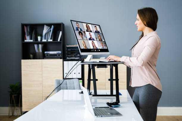 Adjustable Height Desk Stand In Office Adjustable Height Desk Stand In Office Using Computer posture photos stock pictures, royalty-free photos & images