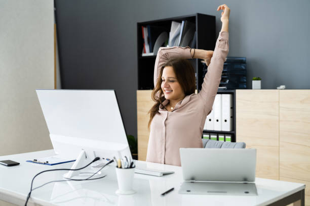 istock Woman Stretching At Office Desk 1305332145